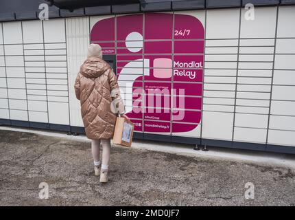 Loriol sur Drome, Frankreich - 14. Januar 2023: Abholung eines Pakets aus einem Mondial`Relay-Schließfach durch eine junge Frau. Schließfächer Mondial Relay. Pickup-Box. Stockfoto